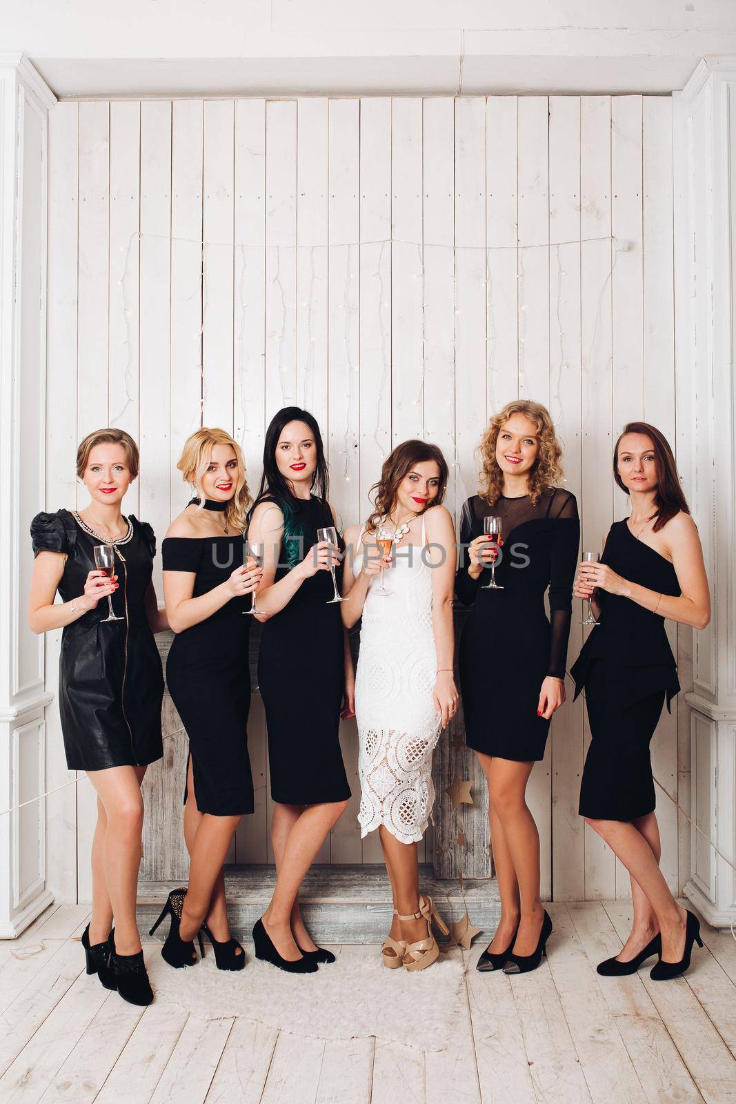 Beautiful girls in black dresses toasting with bride. by StudioLucky