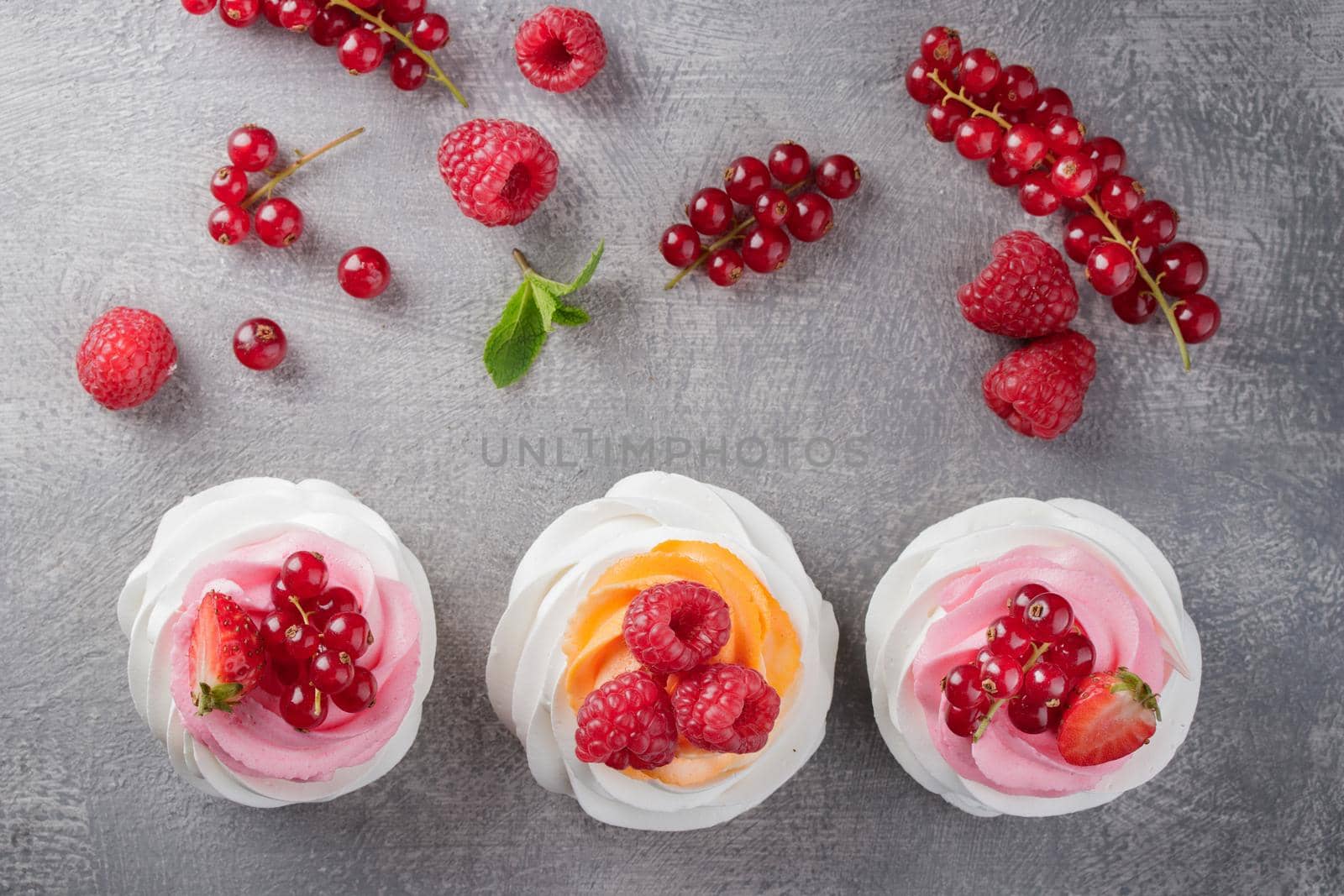 Pavlova dessert with berries on a gray background