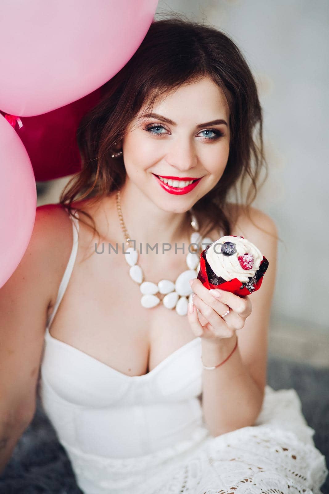 Smiling bride-to-be with muffin at her hen party. by StudioLucky