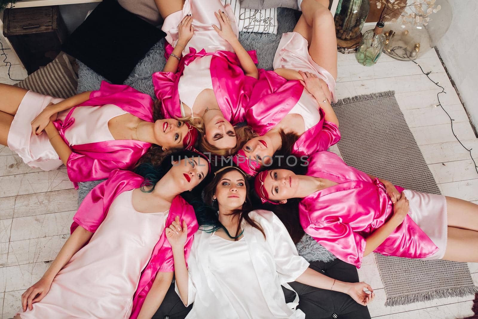 Bridesmaids in pink bathrobes with bride. by StudioLucky