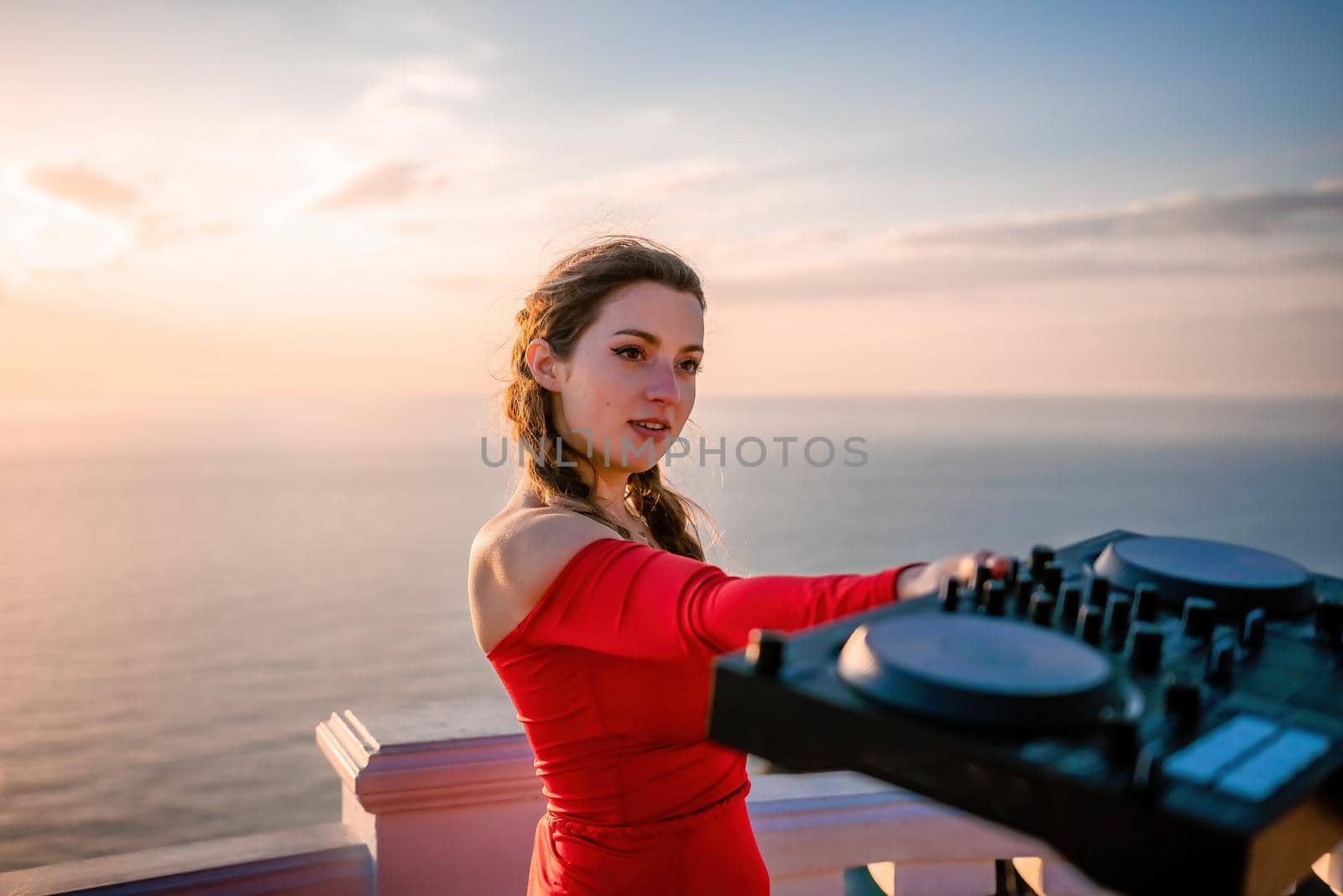 Female Hands of DJ plays music mixing and scratching on evening party. Professional music equipment. Close-up of a DJ console controlled by a young sexy woman. Selective focus.