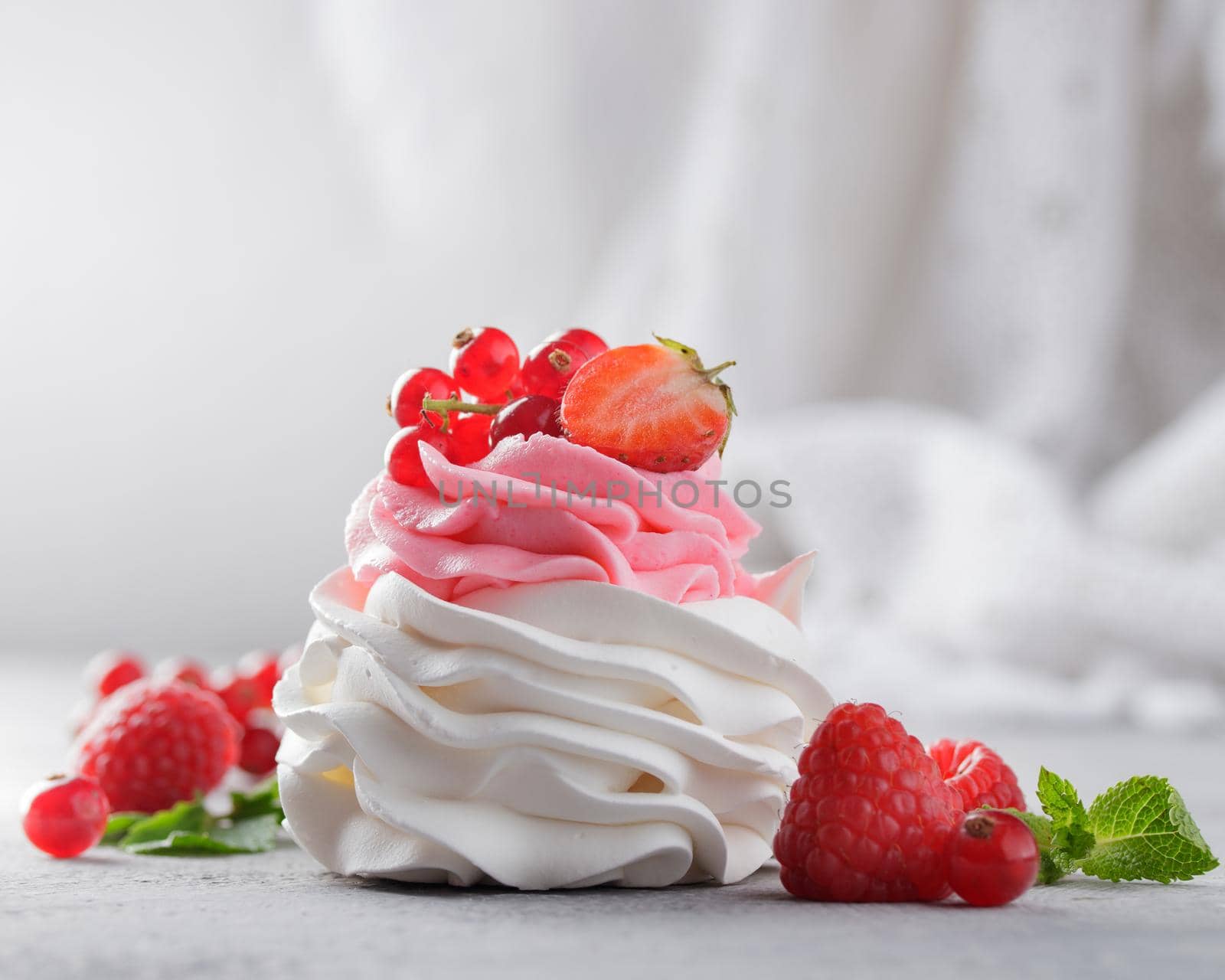 Pavlova dessert with berries on a gray background