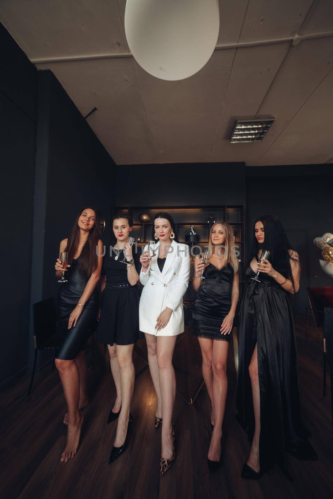 Group of fashion young sexy woman enjoying playing poker and drinking champagne medium long shot. Few glamour rich luxury female relaxing at casino drink alcohol beverage having party