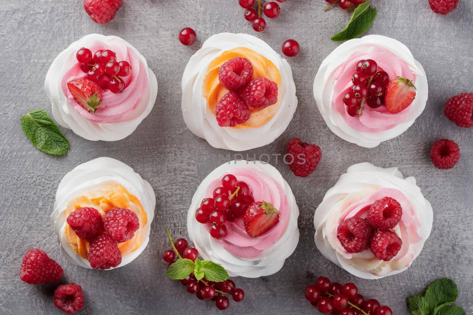 Pavlova dessert with berries on a gray background