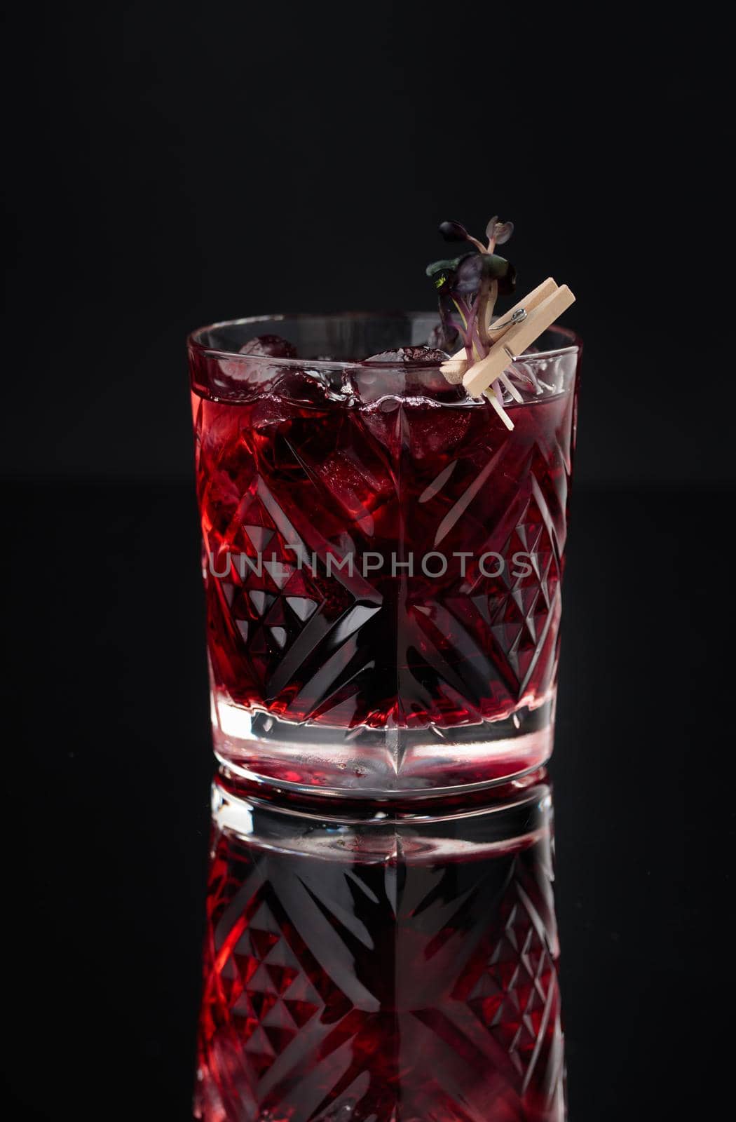 Cocktail in a glass on a black background vertical