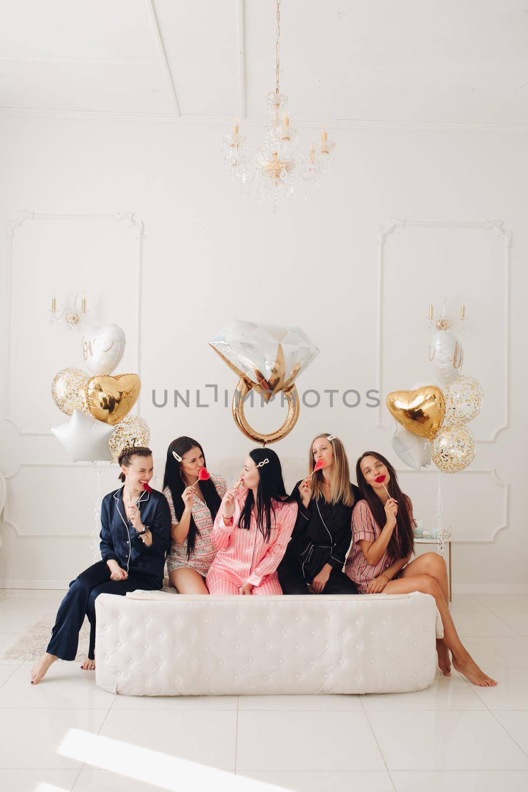 Girlfriends celebrating bachelorette party. Stock photo of five girls in pajamas by StudioLucky