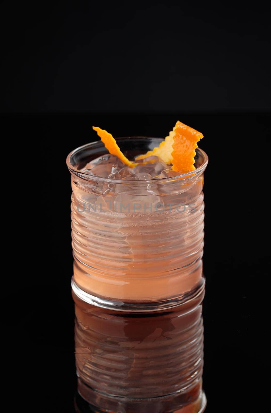 Cocktail in a glass on a black background vertical
