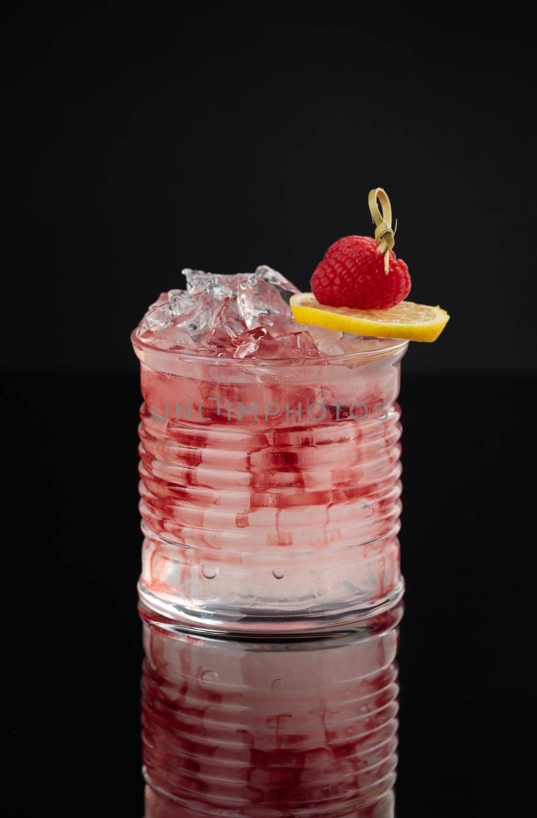 Cocktail in a glass on a black background vertical