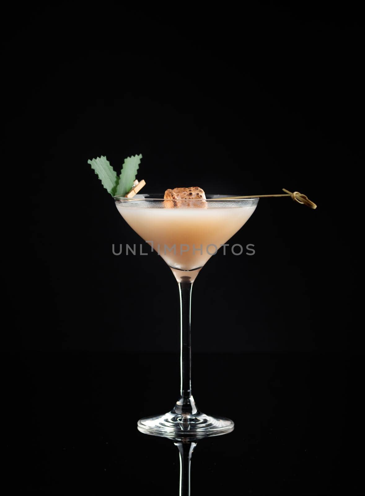 Cocktail in a glass on a black background vertical