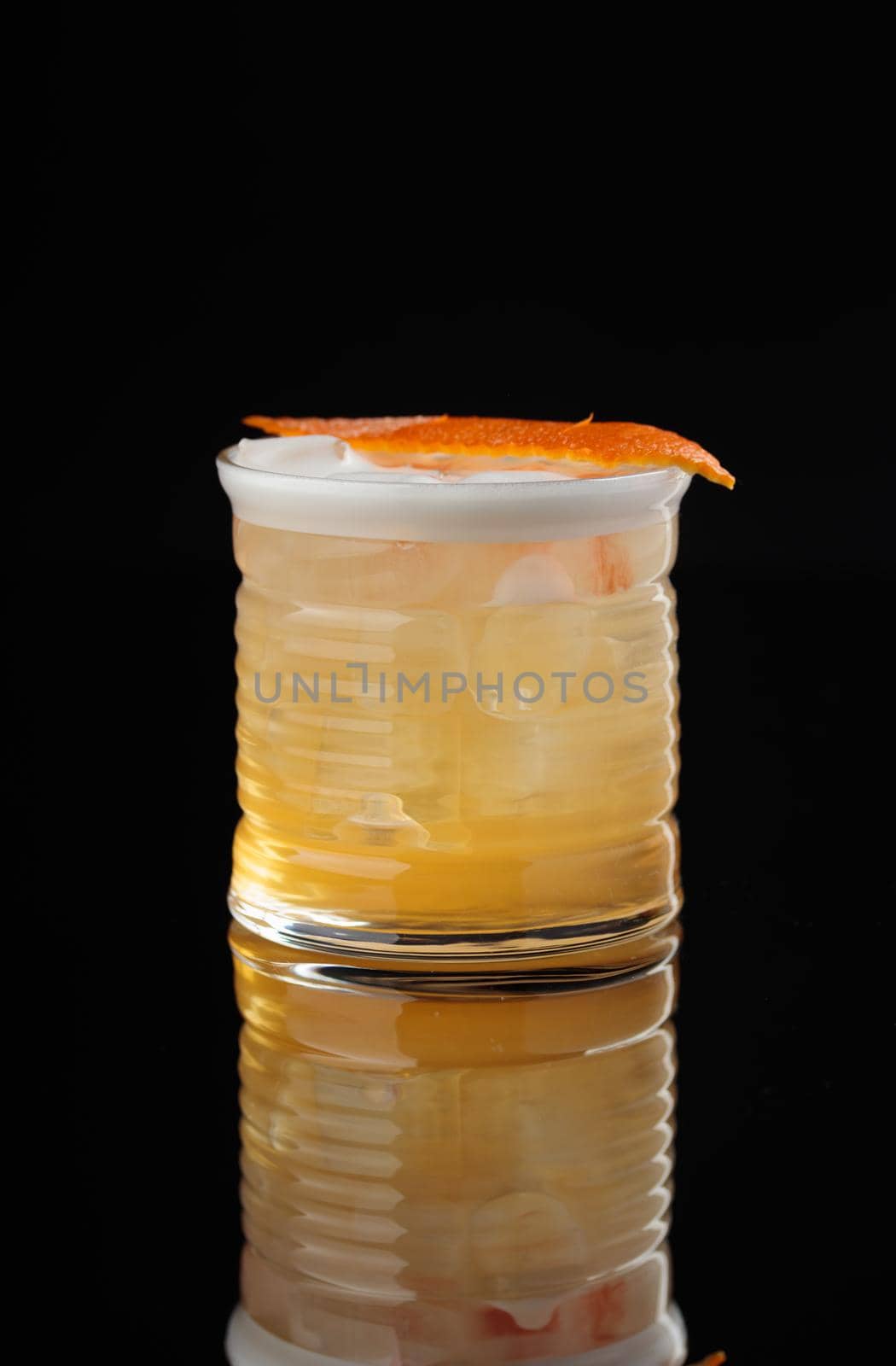Cocktail in a glass on a black background vertical