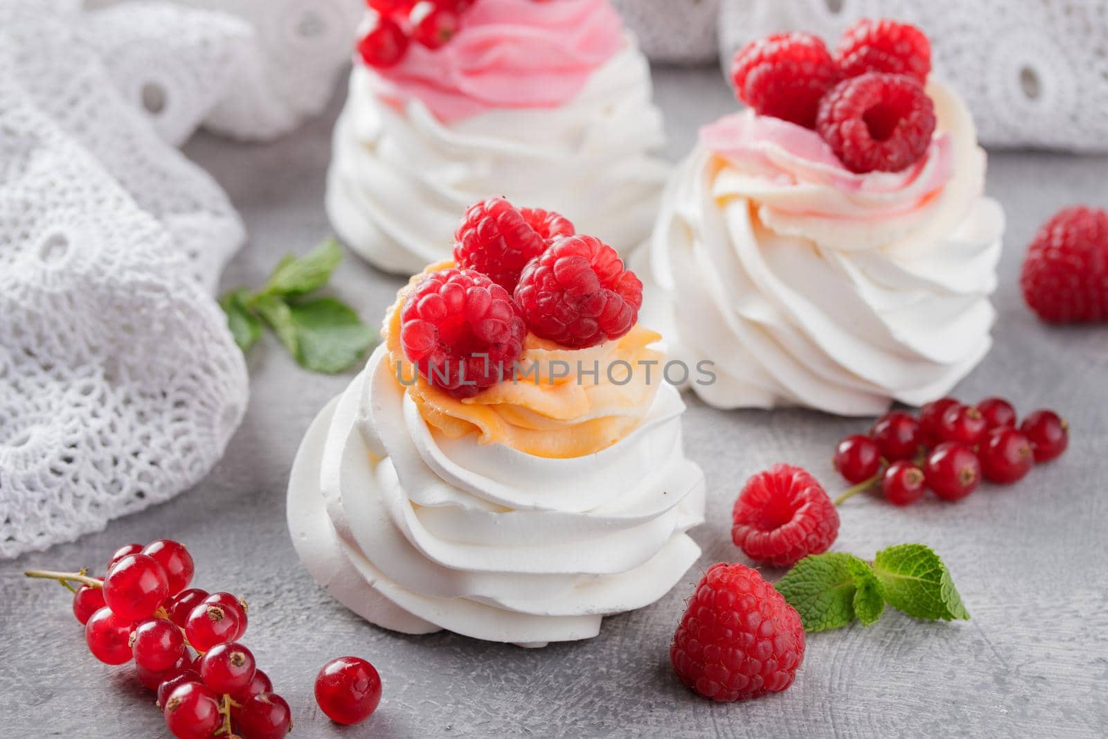 Pavlova dessert with berries on a gray background