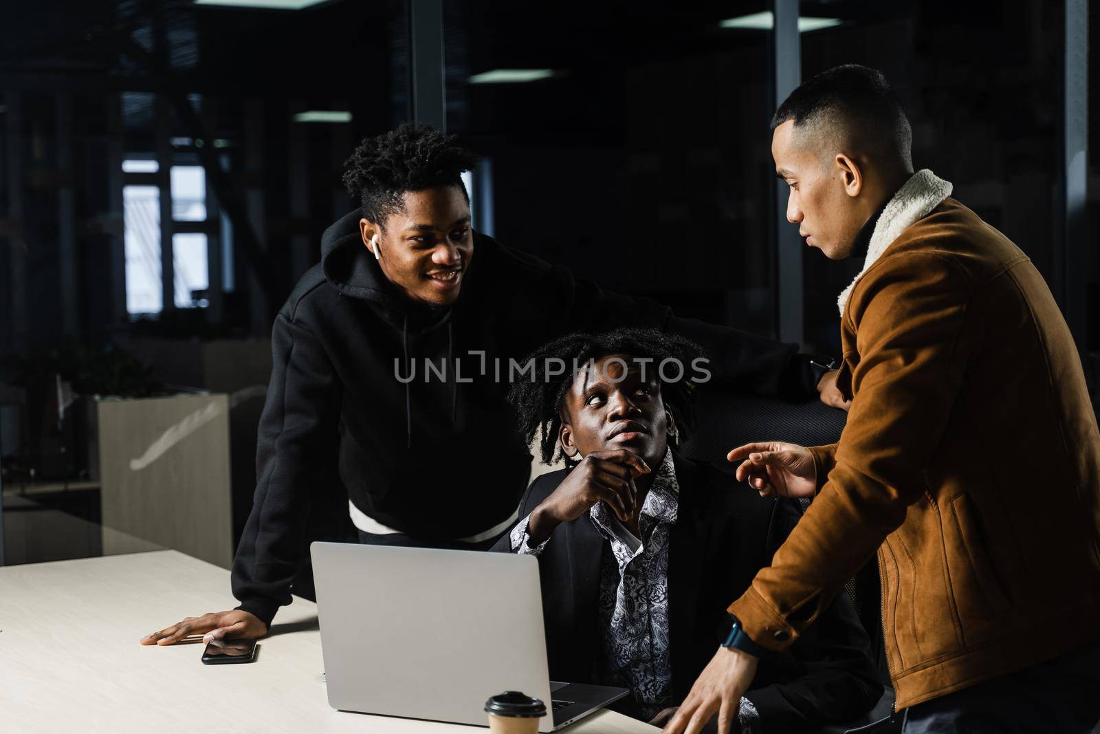 Multiethnic teambuilding and discussing online work project. Black and asian colleagues working on laptop together