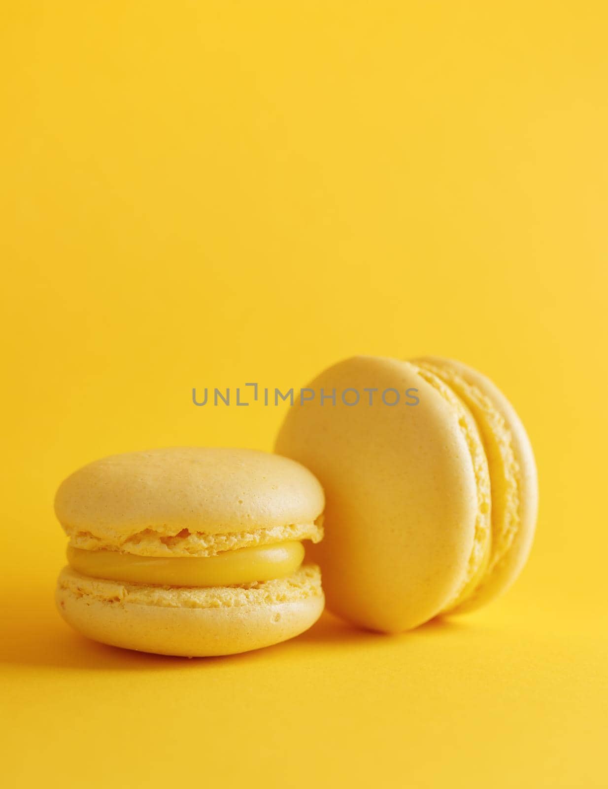 Lemon macaroons on a yellow background vertical