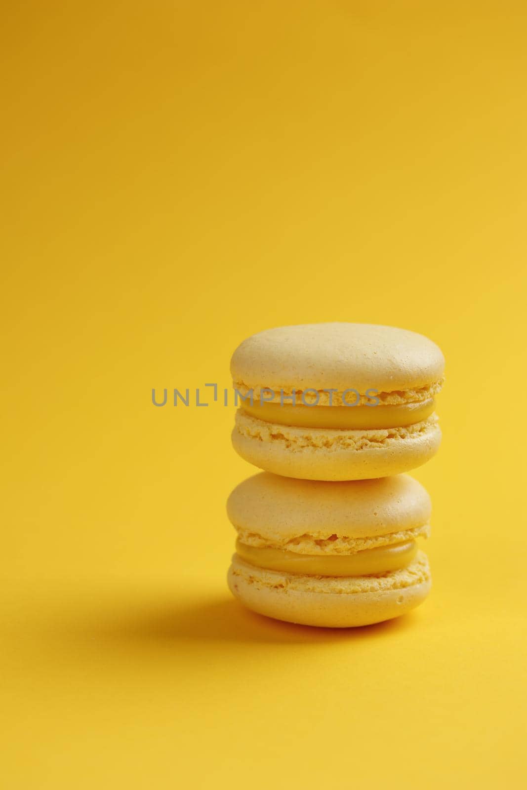 Lemon macaroons on a yellow background vertical