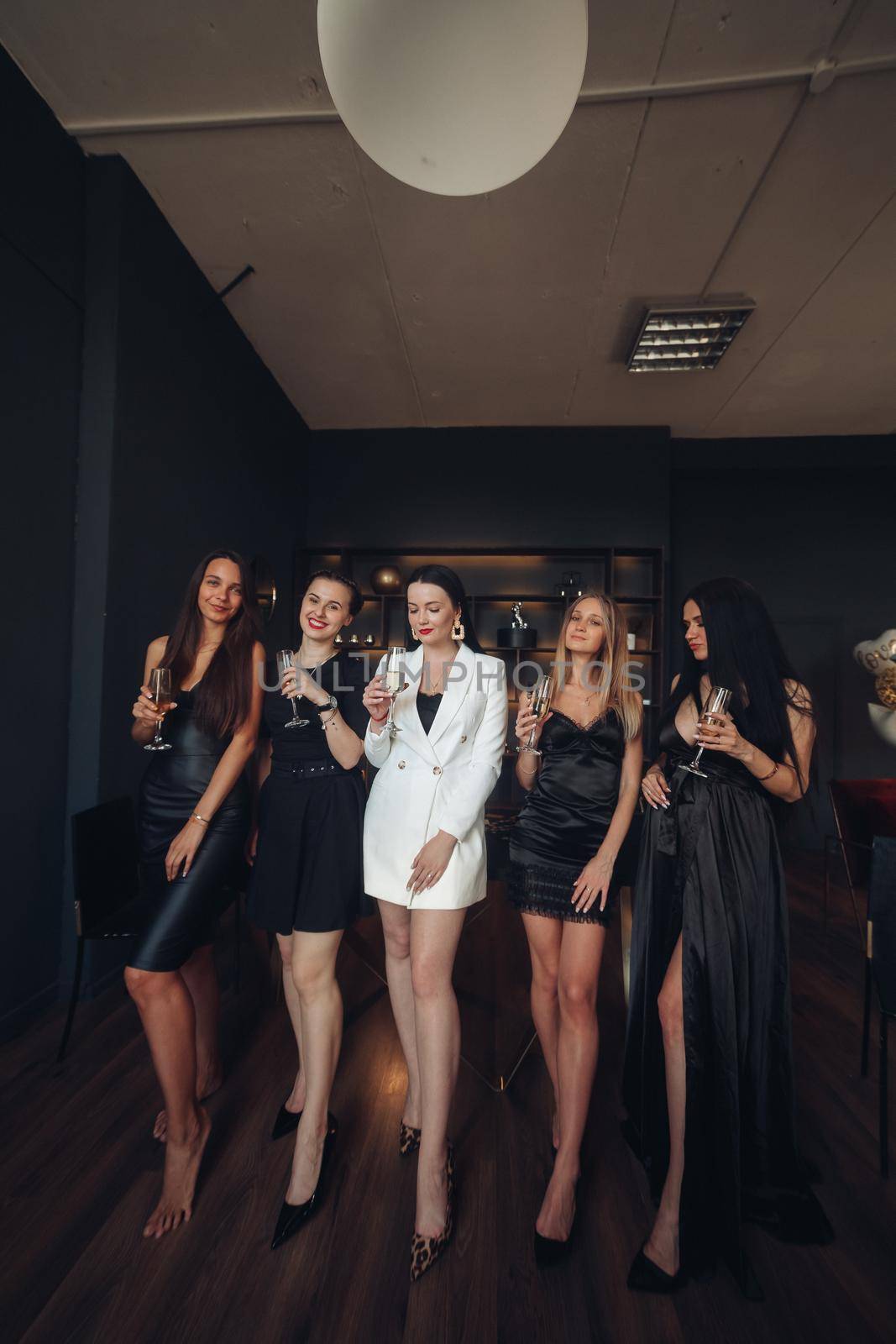 Group of fashion young sexy woman enjoying playing poker and drinking champagne medium long shot. Few glamour rich luxury female relaxing at casino drink alcohol beverage having party