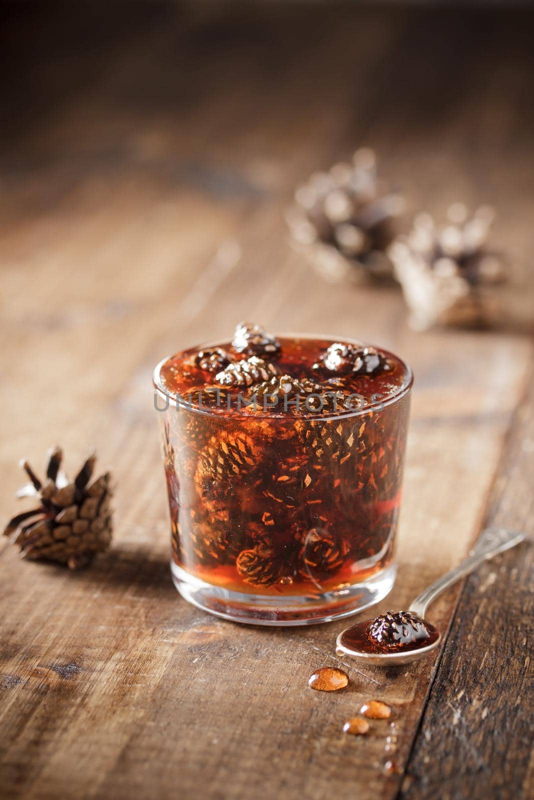 Delicious cone jam in a jar on a wooden background