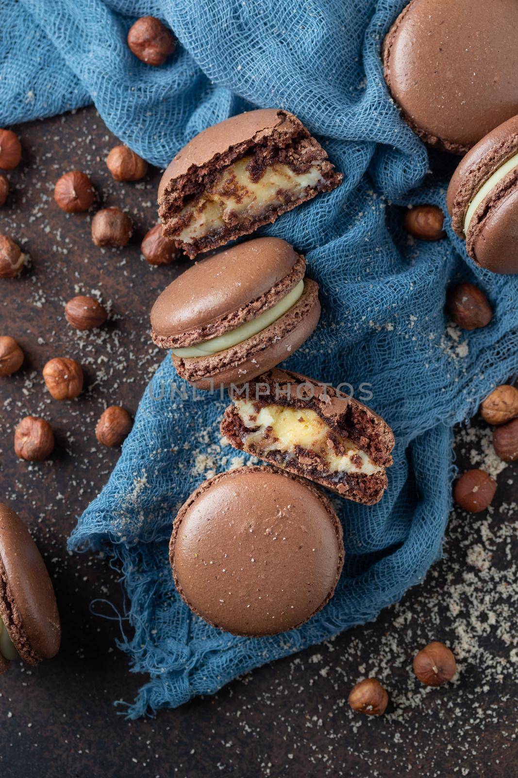 Chocolate macaroons with hazelnut flour on a blue textile