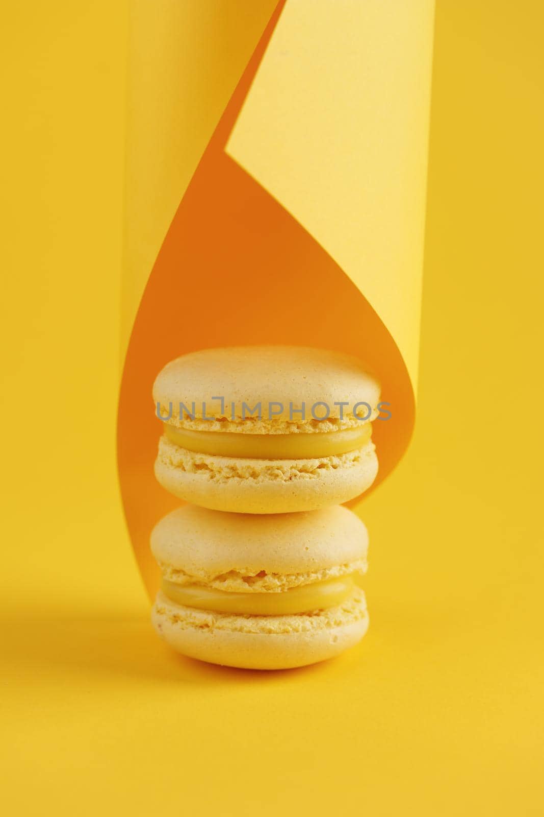 Lemon macaroons on a yellow background vertical