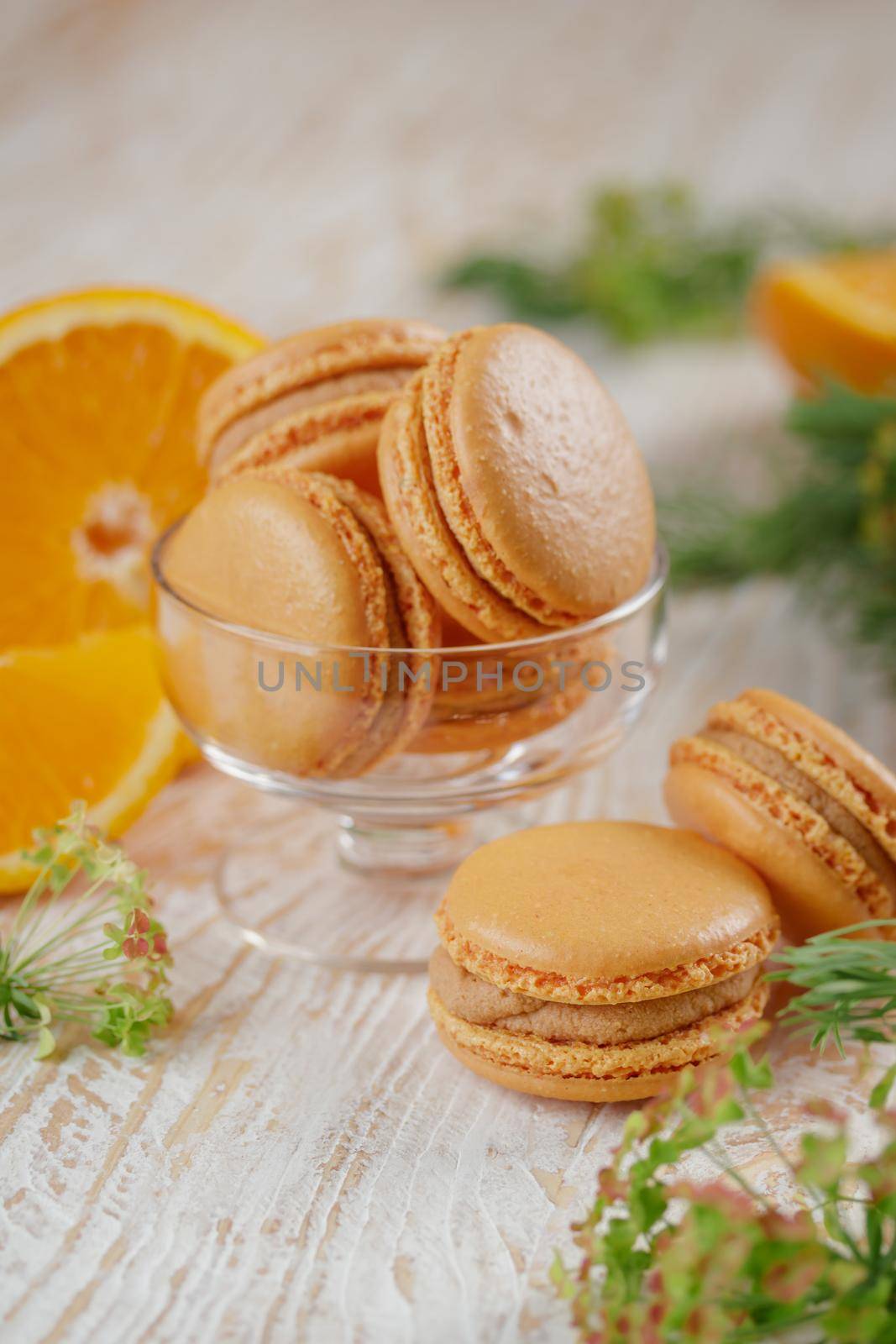 Macaroons with orange and caramel on a wooden table