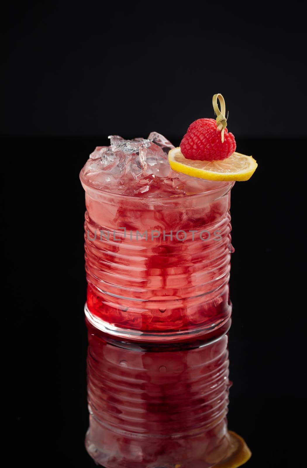 Cocktail in a glass on a black background vertical