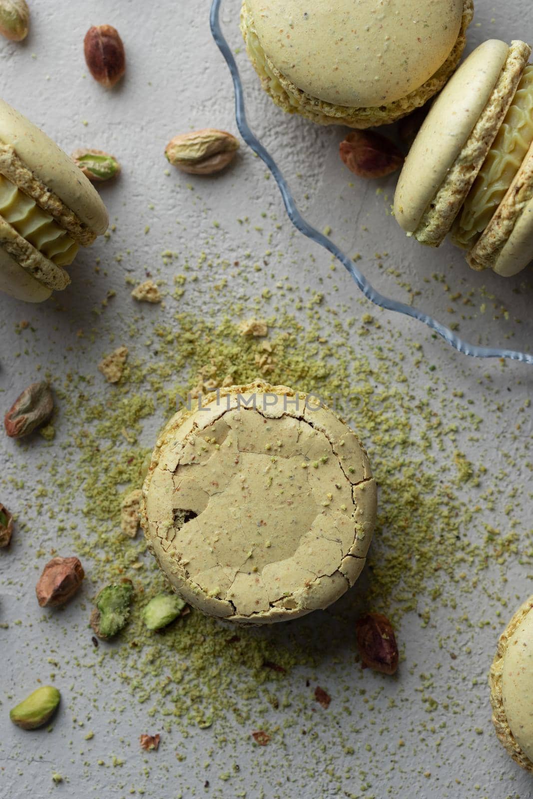 Pistachio flour and green macaroons on a gray background