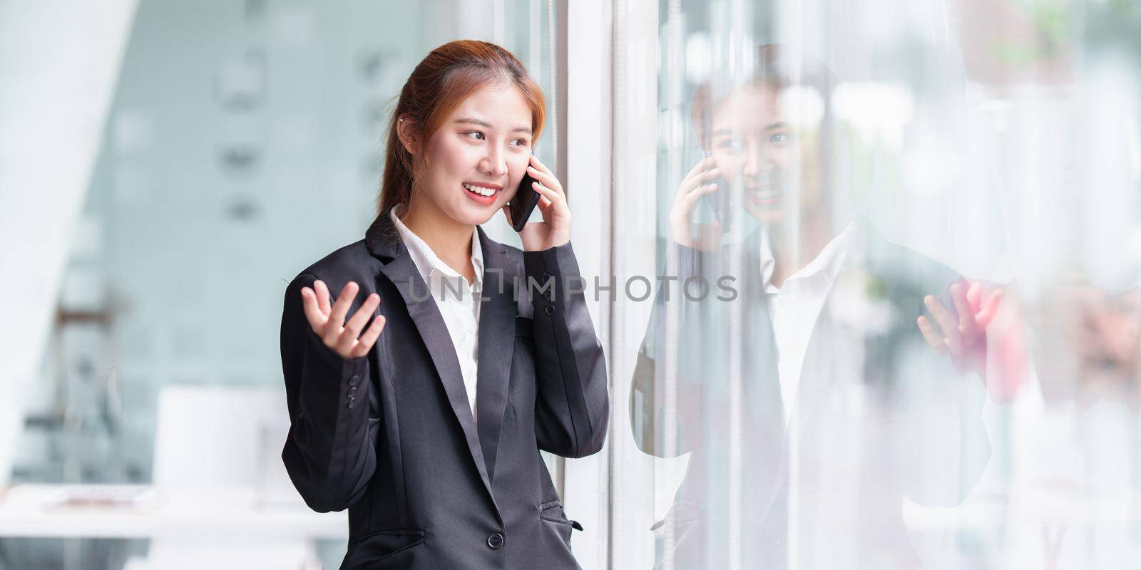 Portrait of Asian Business or Accountant woman talking with client by cell phone