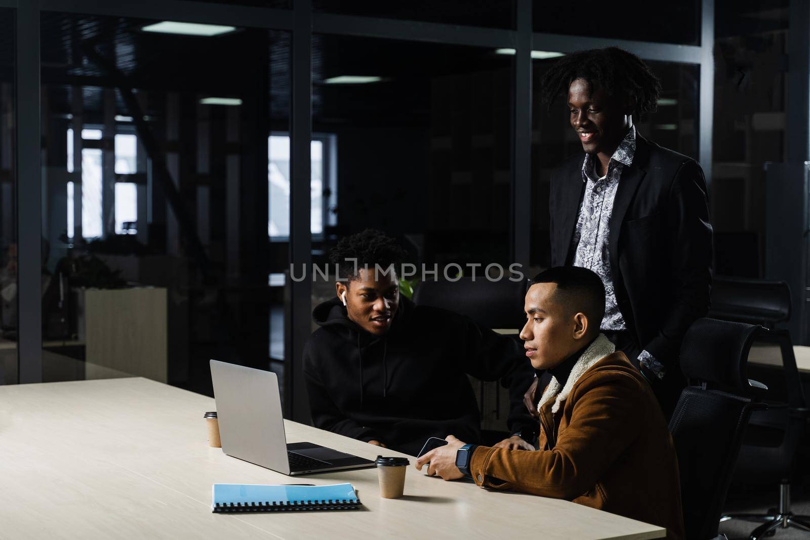 Multinational brainstorm group of colleagues working online on project in briefing room. Black african business man and asian work in team together