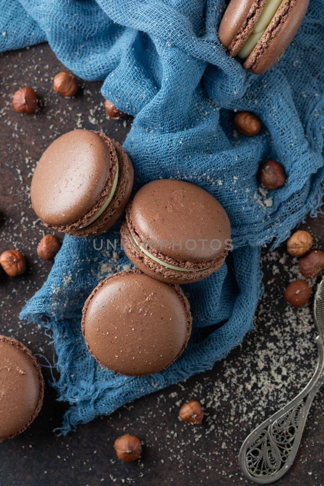 Chocolate macaroons with hazelnut flour on a blue textile