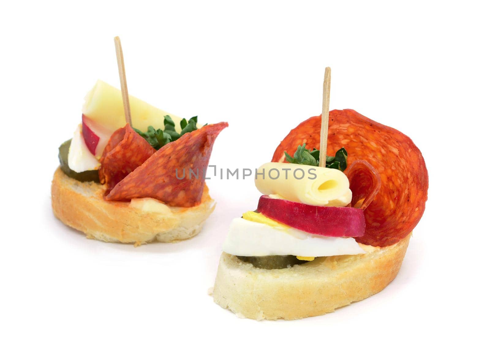 Two fresh salami cheese canapes on white background.