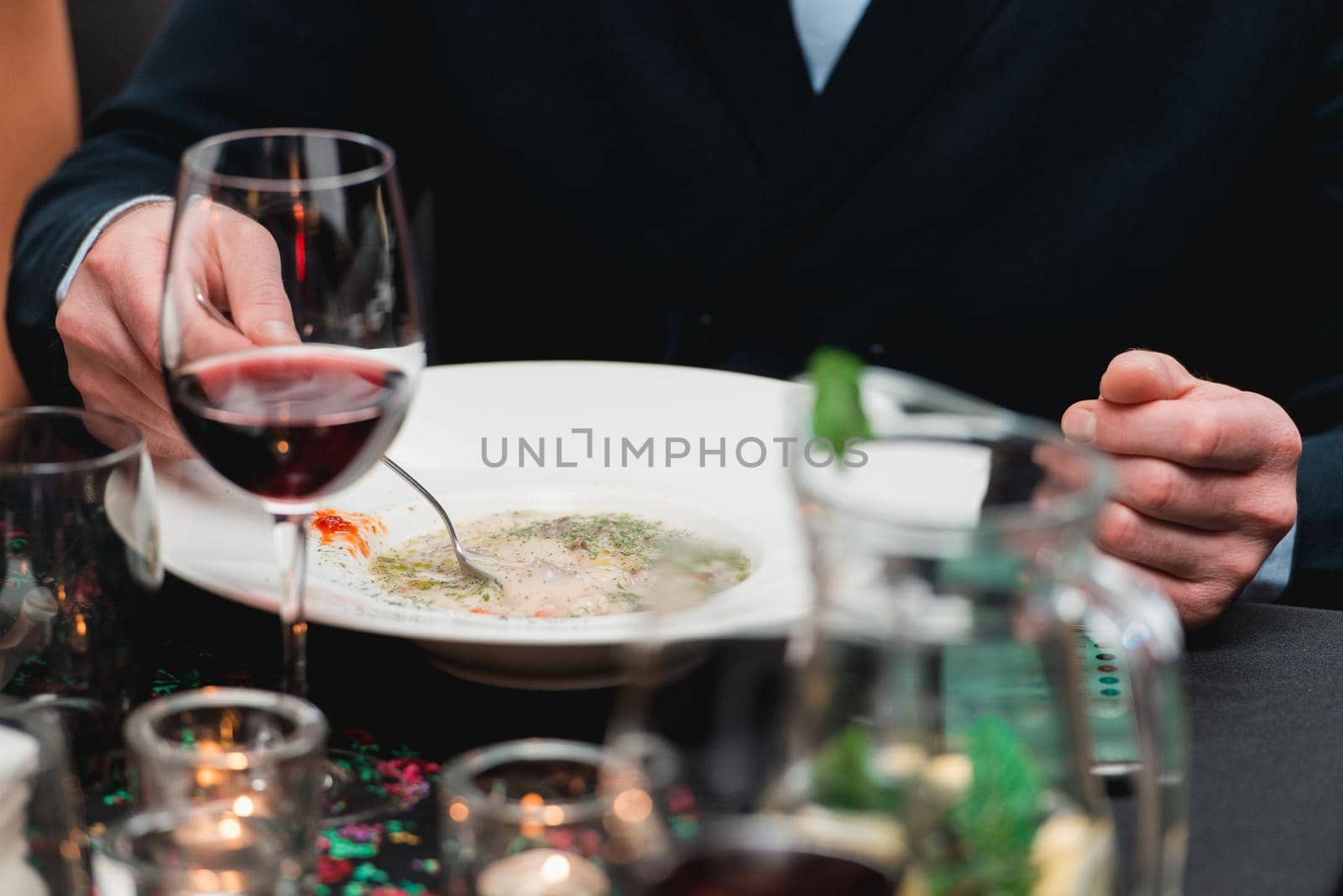 Man eating mushroom cream soup in a restaurant.