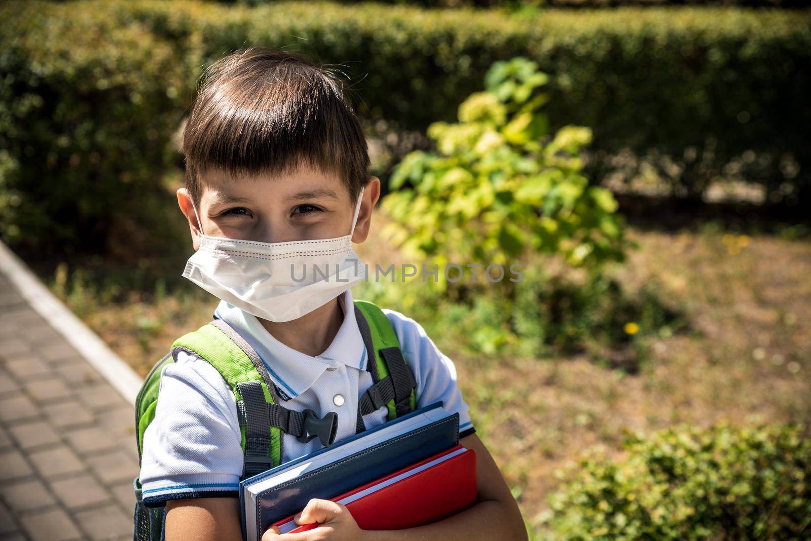 Child wearing face mask going at reopen school after covid-19 quarantine and lockdown. It is new normal for protection and prevention while outbreak of coronavirus or flu. Kids back to school concept.