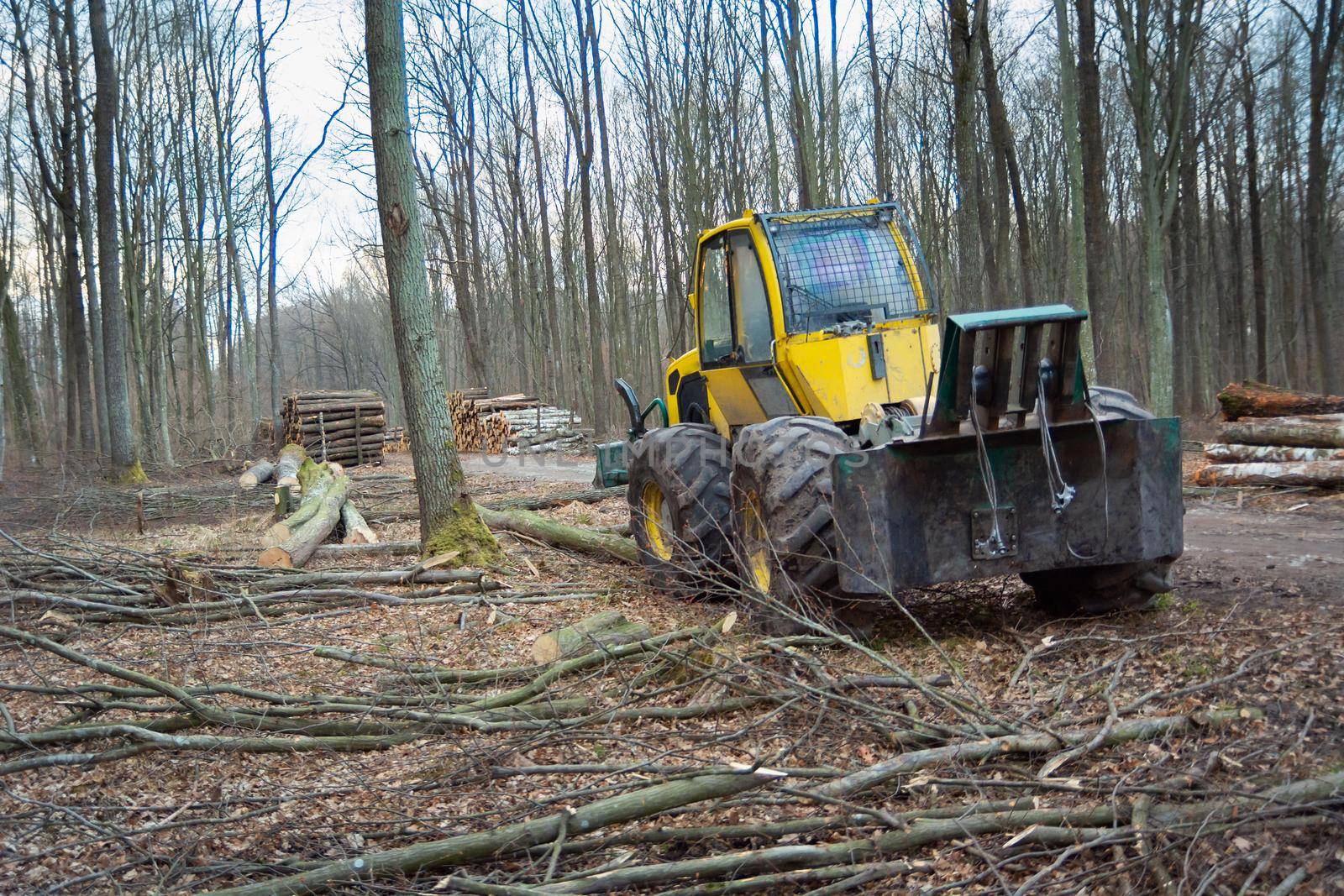 High-powered yellow tractor with rope winch standing in the forest
