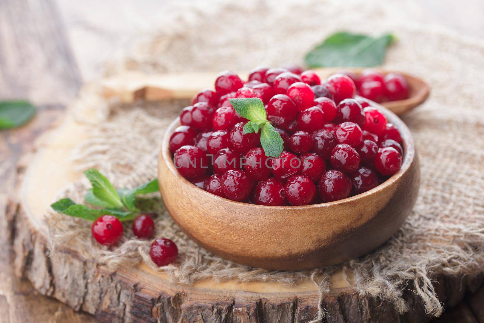 Frozen cranberry berries in a wooden bowl on a table
