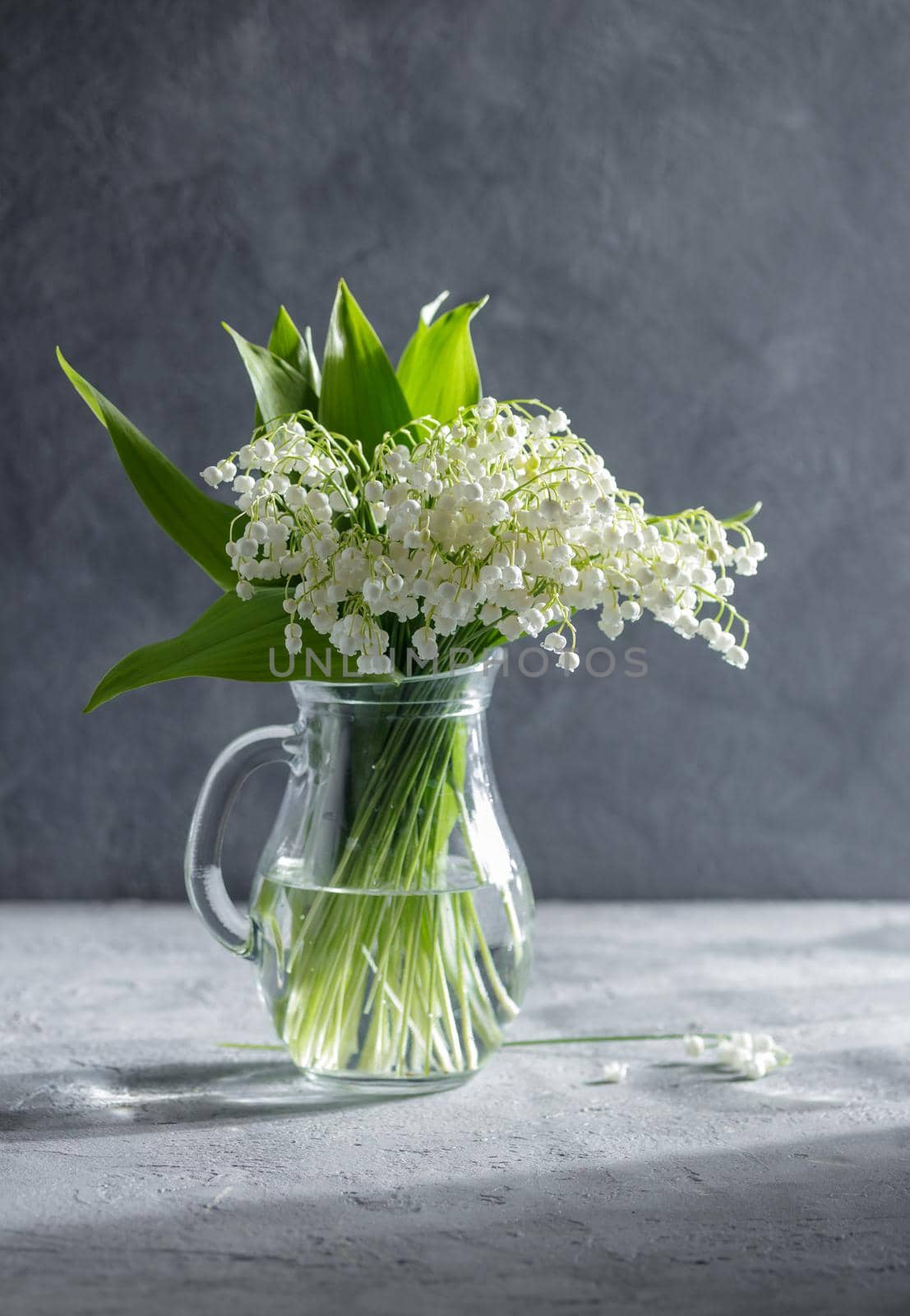 Lilies of the valley in a glass vase on a table