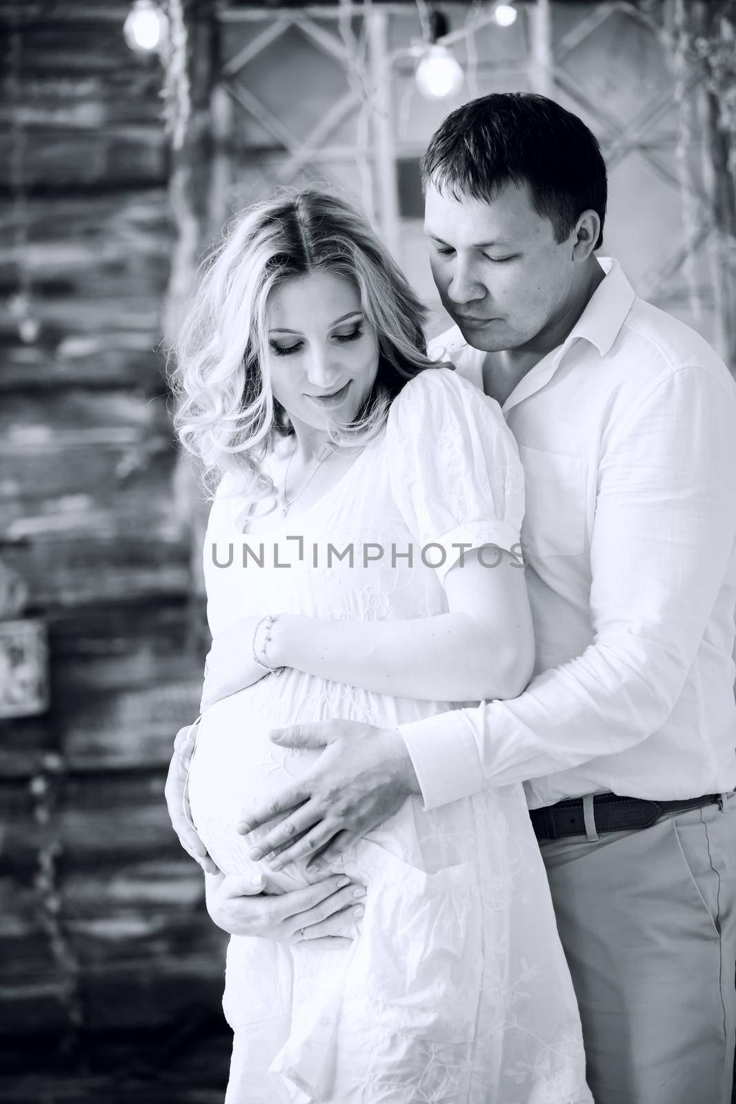 photo in retro style. loving husband hugging his pregnant wife. the concept of parenthood