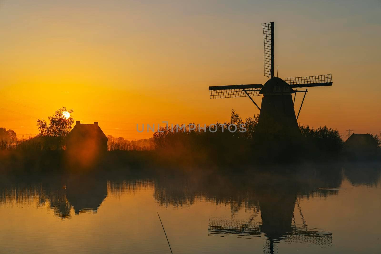 Traditional Dutch windmills with a colourful sky just before sunrise in Kinderdijk, The Netherlands