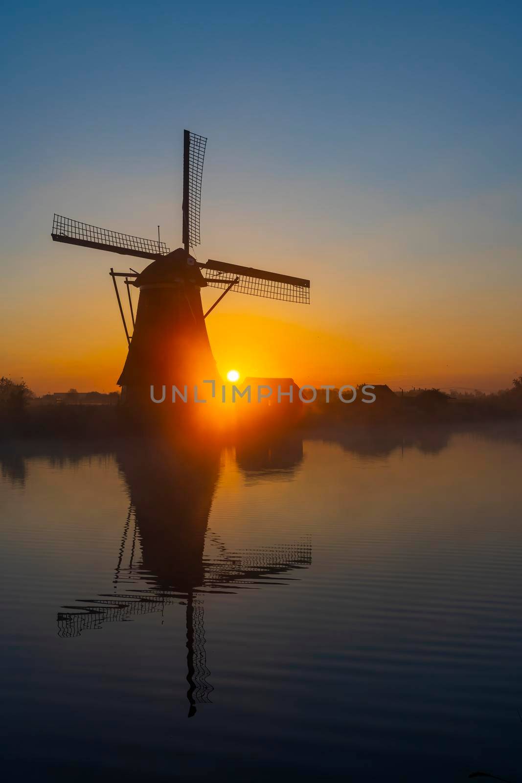 Traditional Dutch windmills with a colourful sky just before sunrise in Kinderdijk, The Netherlands