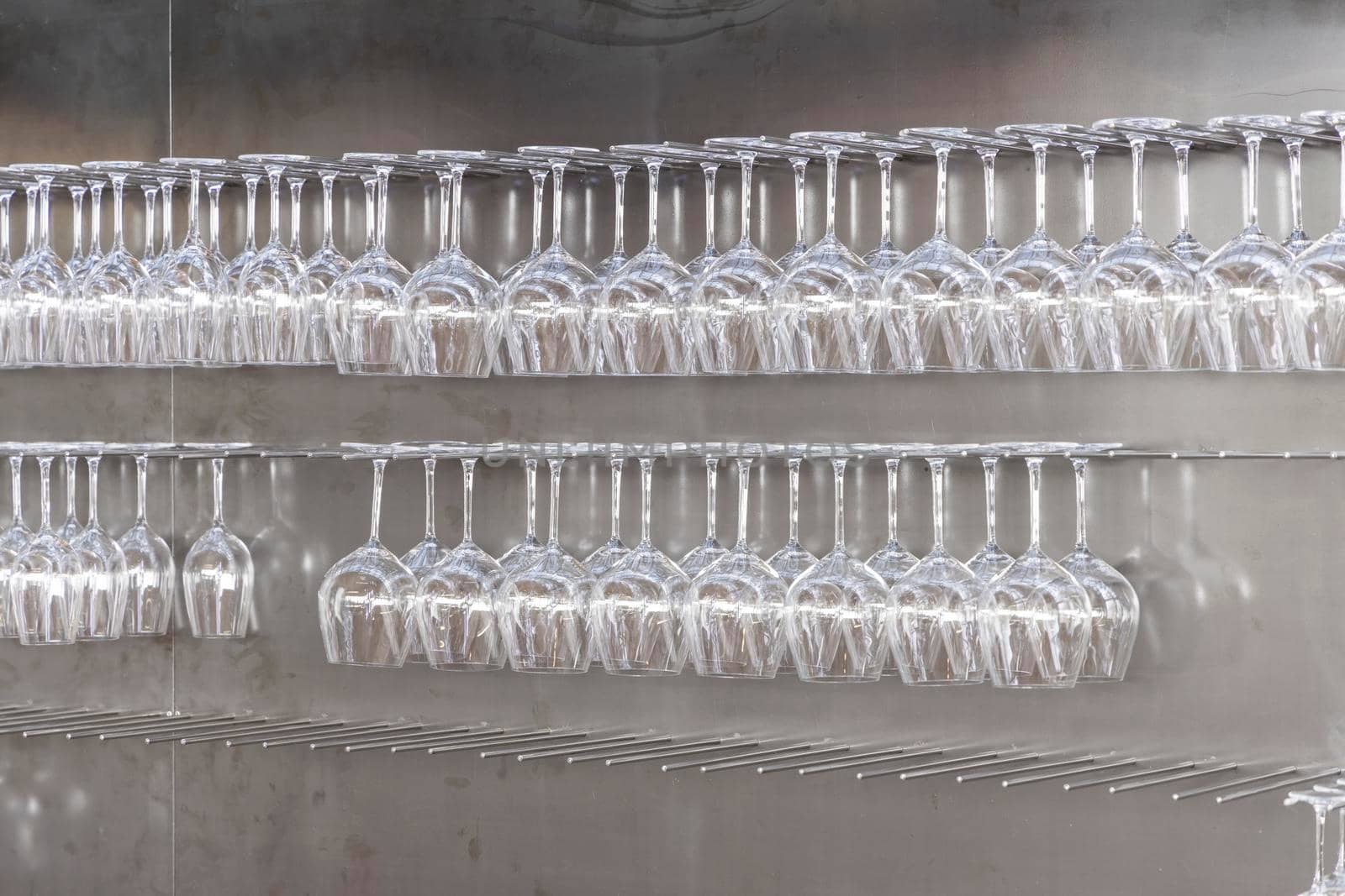 Wine glasses hanging on wall in wine shop by phbcz