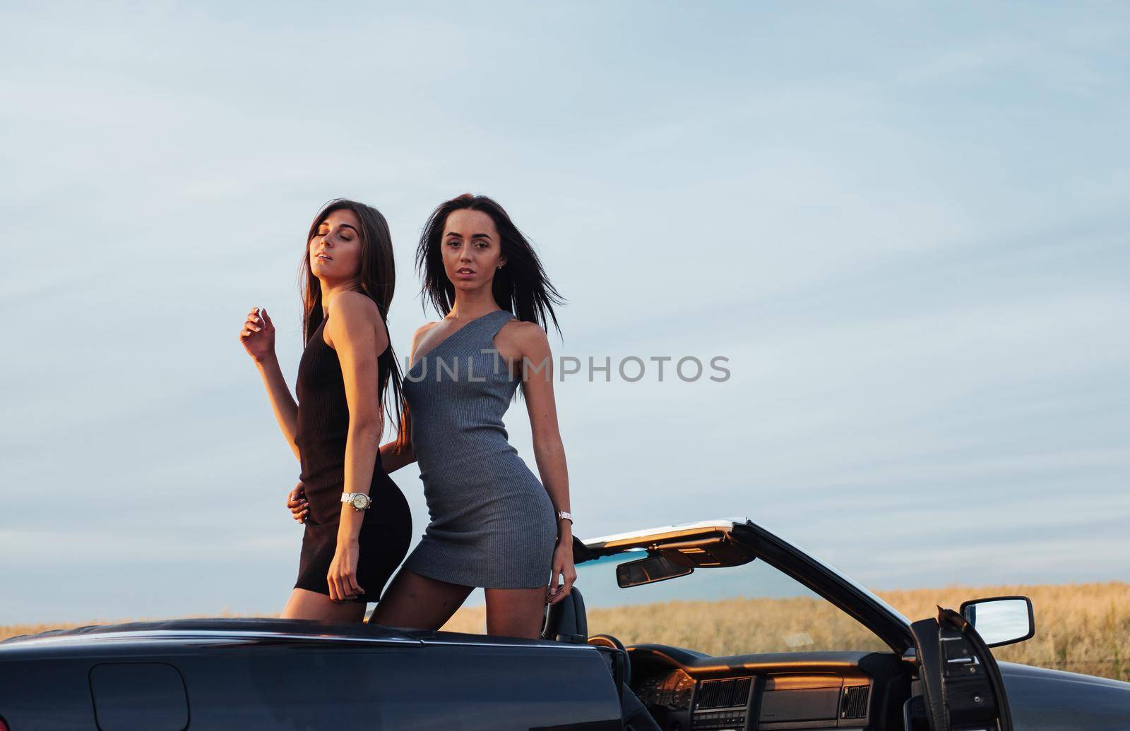 Two women in a black car on the roadside roads.
