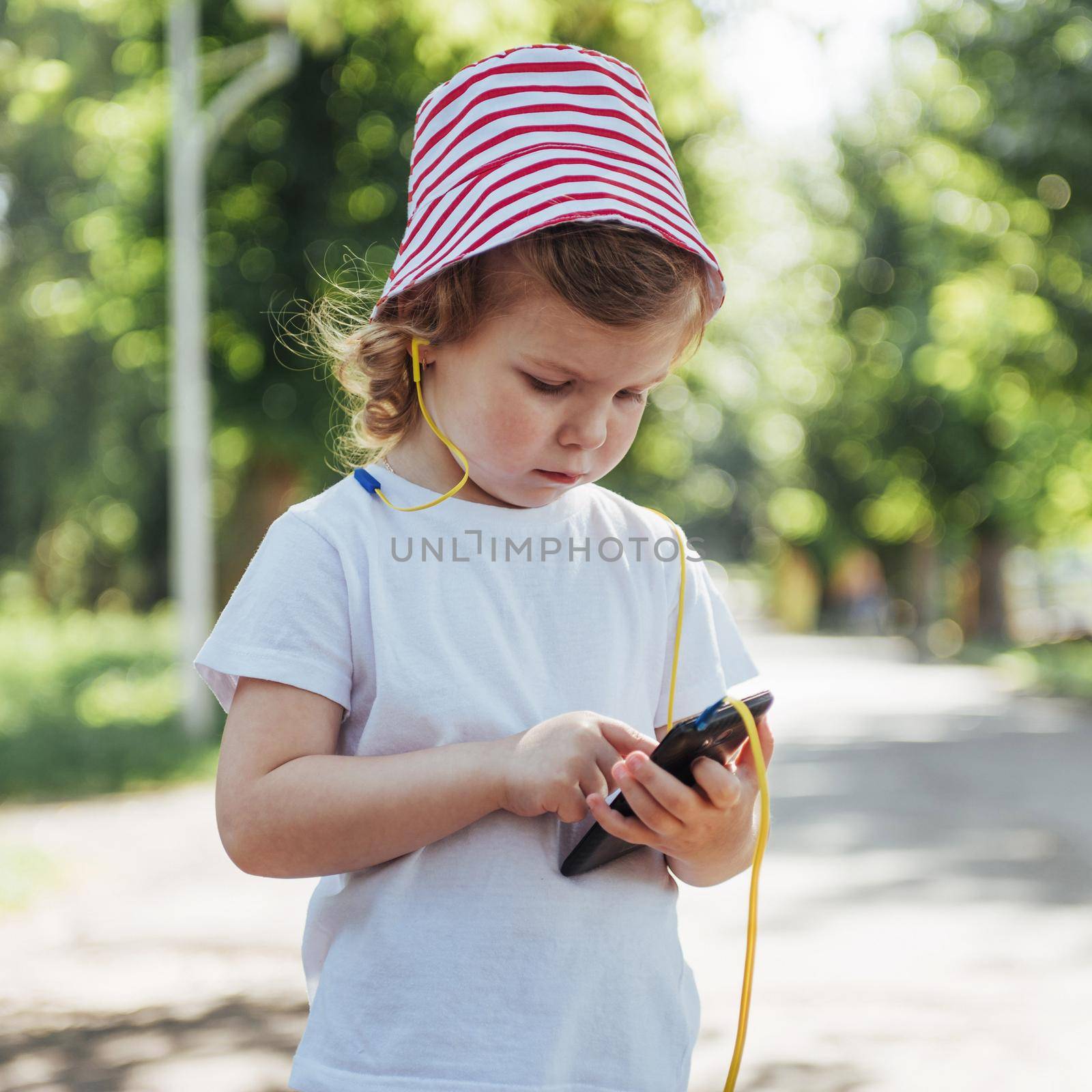 Cute girl listening to music with headphones outdoors.