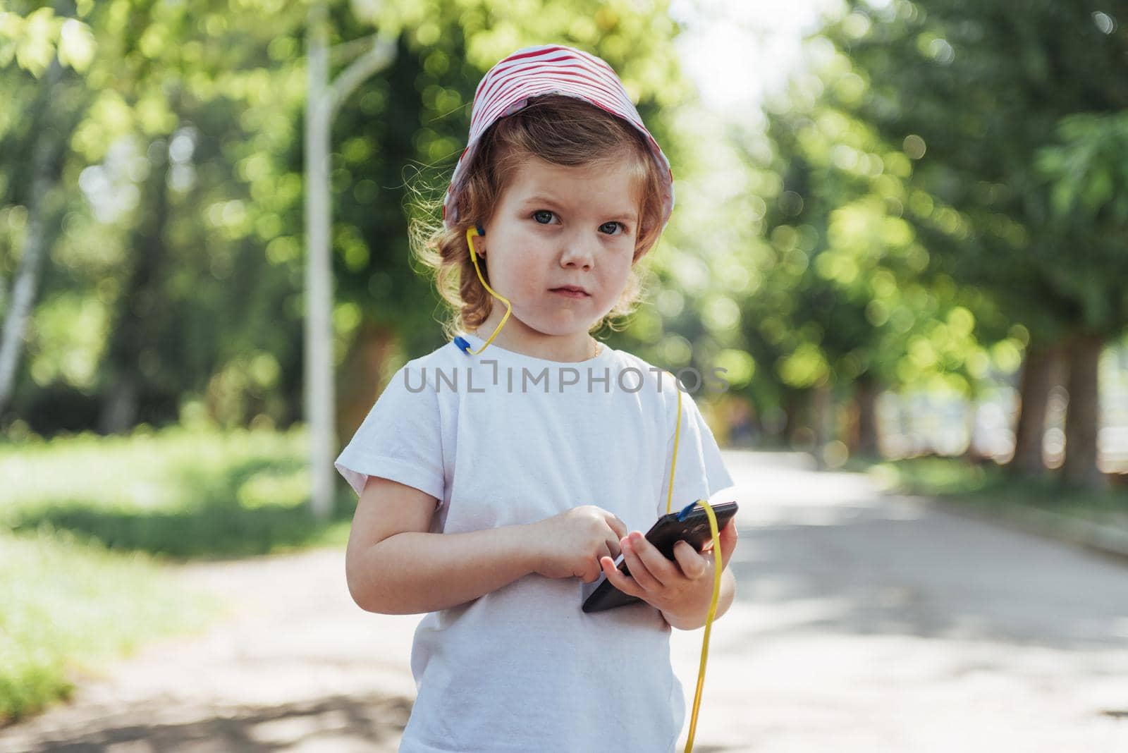 Cute girl listening to music with headphones outdoors.