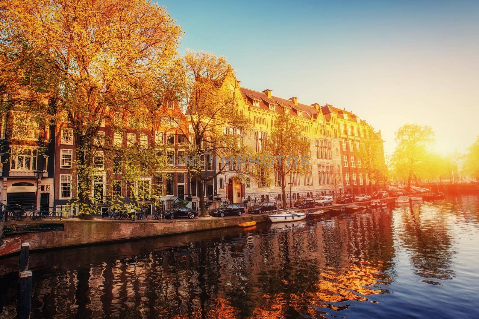 Fantastic sunset that shines on buildings and reflected in the water. Amsterdam is the capital and most populous city in Netherlands.