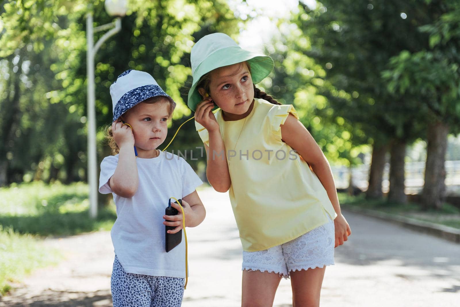 Happy girl with headphones to share music from your smartphone on street