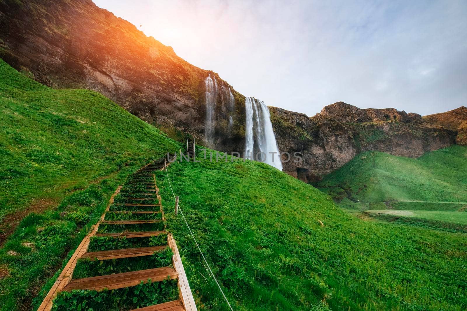 Seljalandfoss waterfall at sunset. Bridge over the river. Fantastic nature. Iceland. Europe