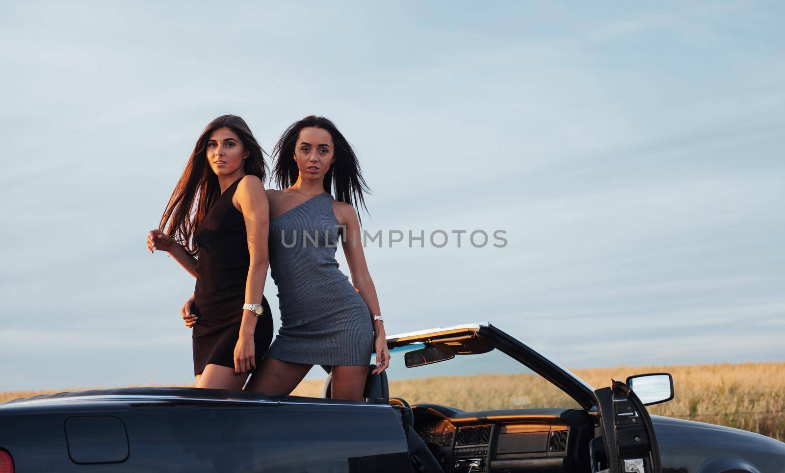 Two women in a black car on the roadside roads.