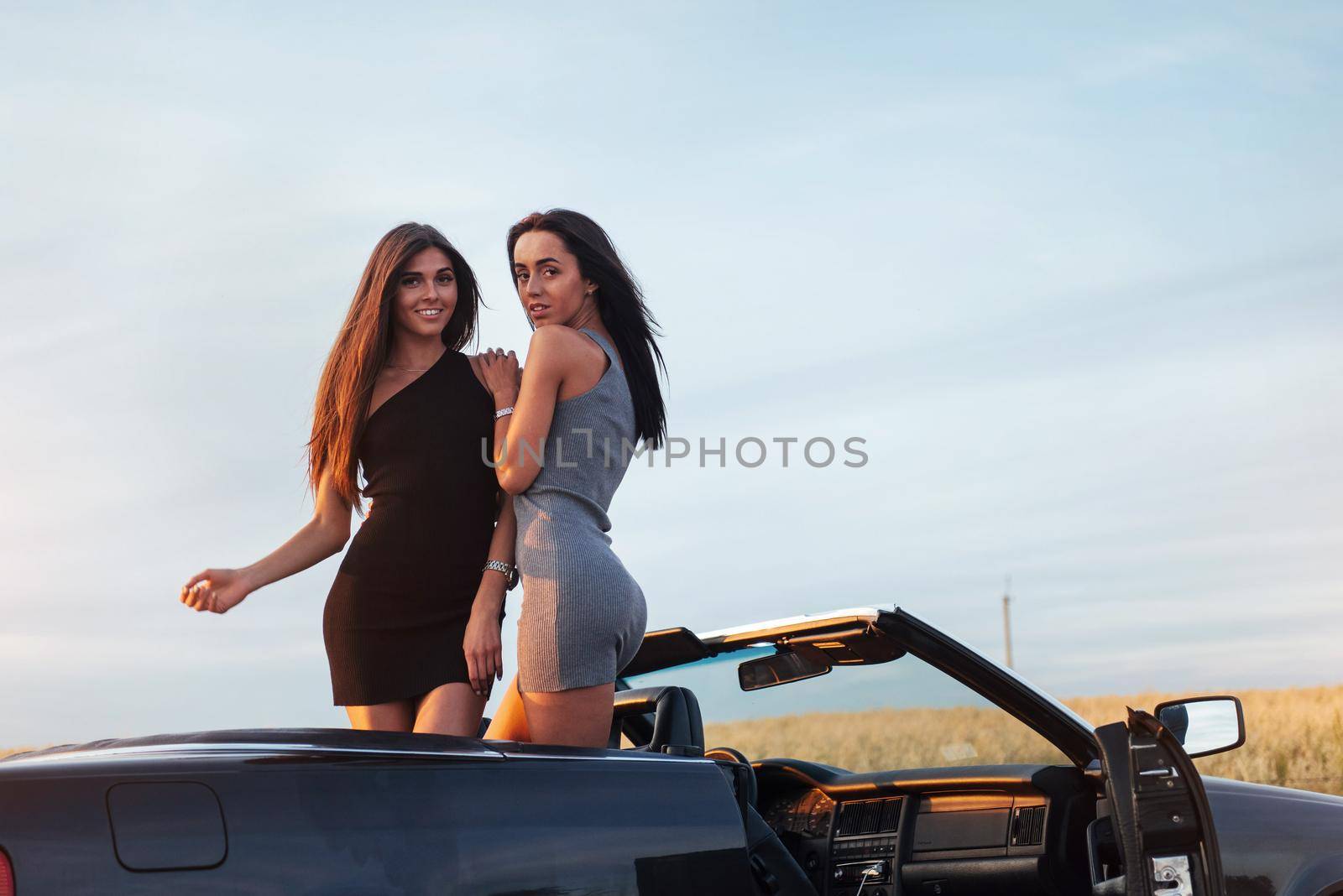 Two women in a black car on the roadside roads by Standret