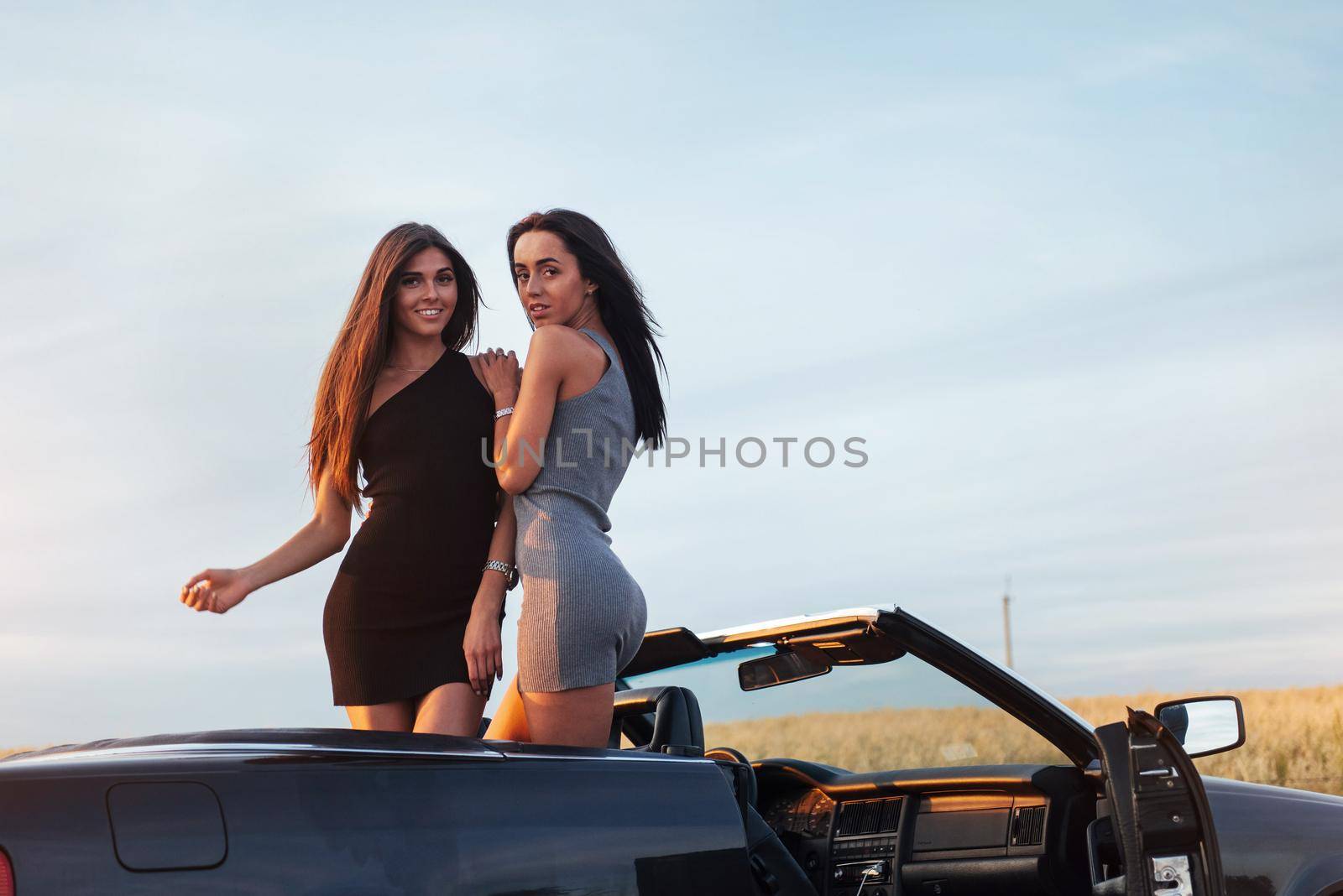 Two women in a black car on the roadside roads.