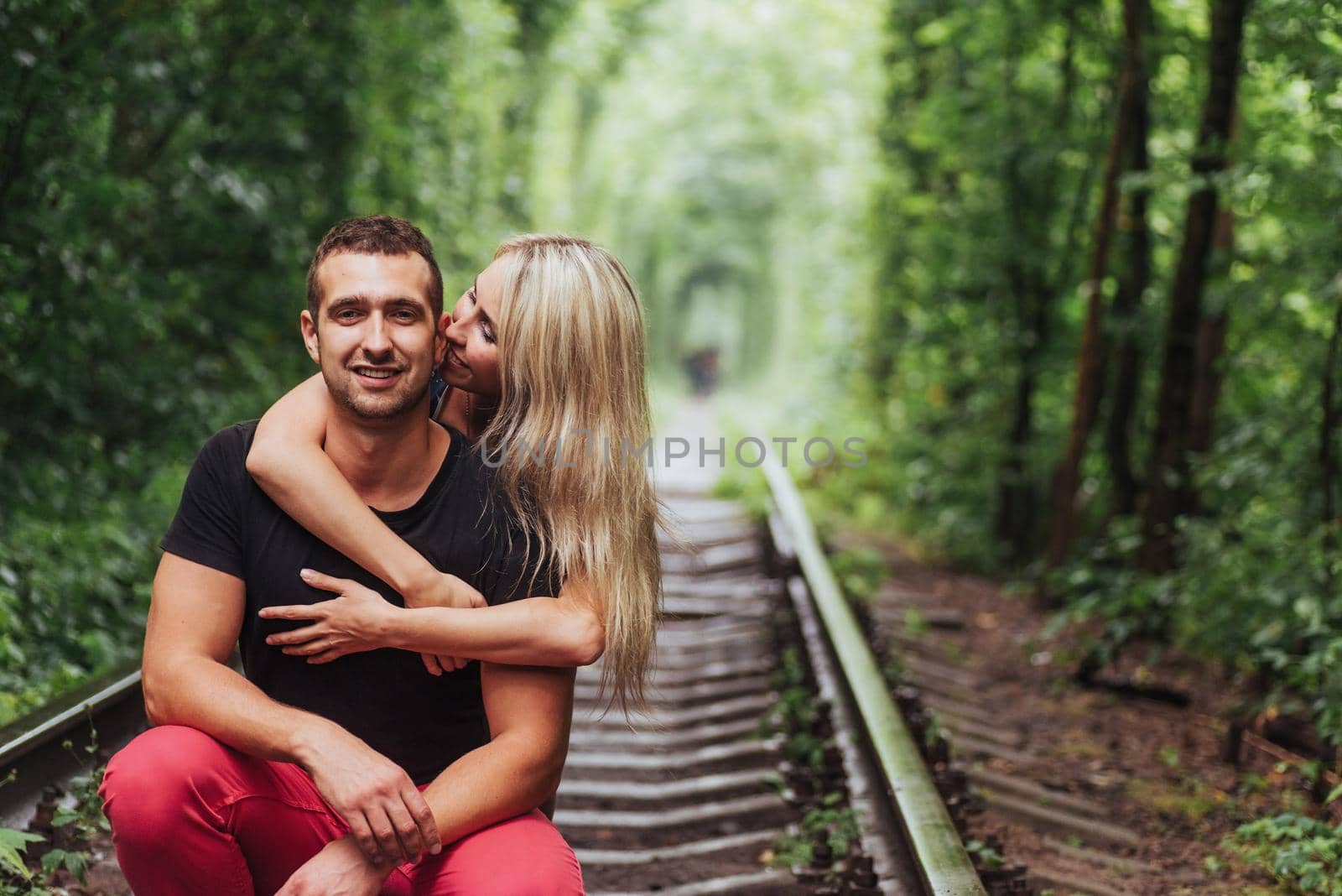 Loving couple in love tunnel iron road.