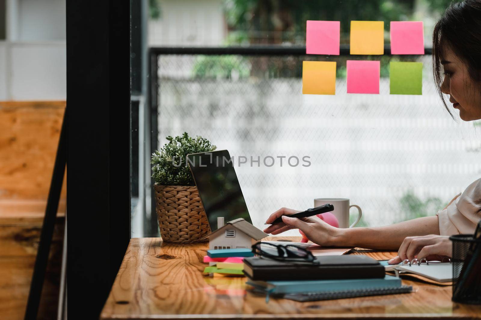 Real estate woman with house model on working desk for investment to buying property.