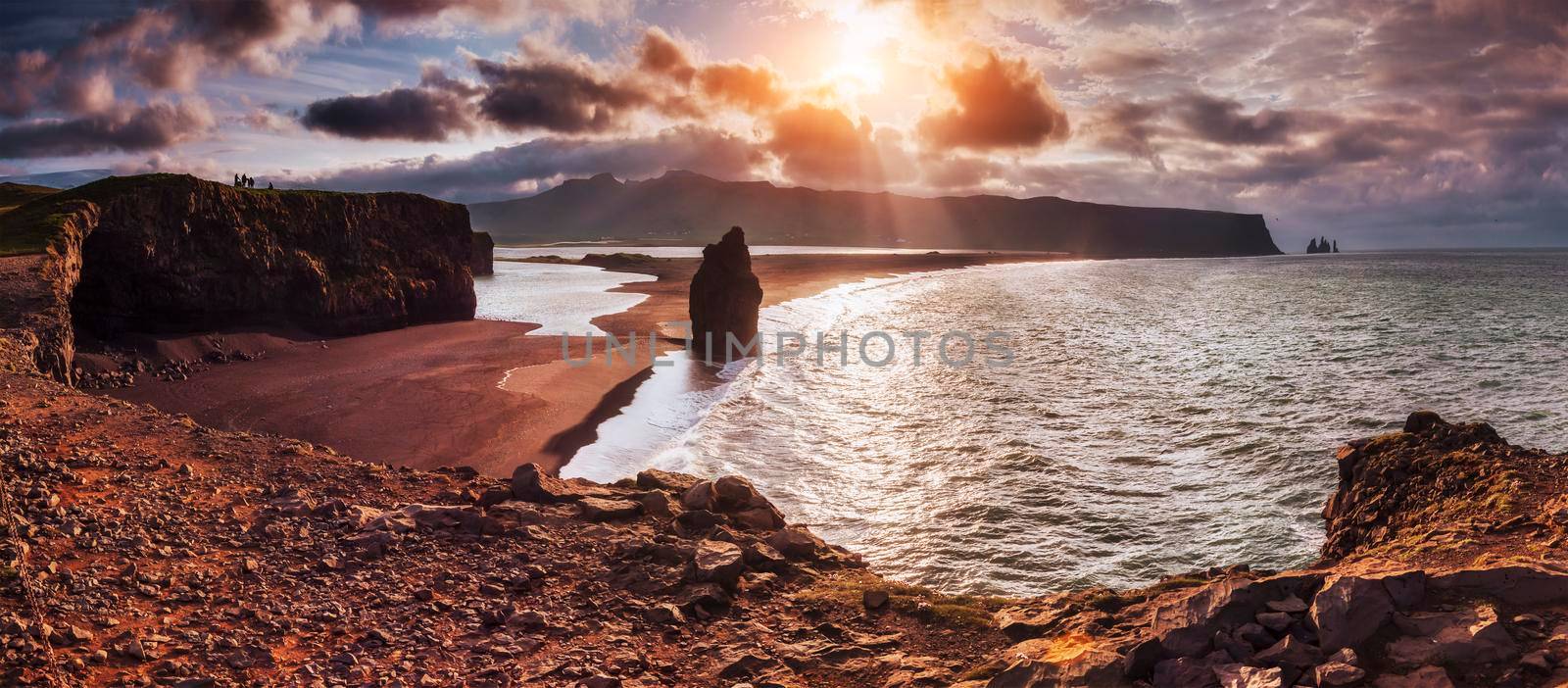 The black sand beach and mountains Reynisfjara Reynisfyal from Cape at sunset in Iceland.